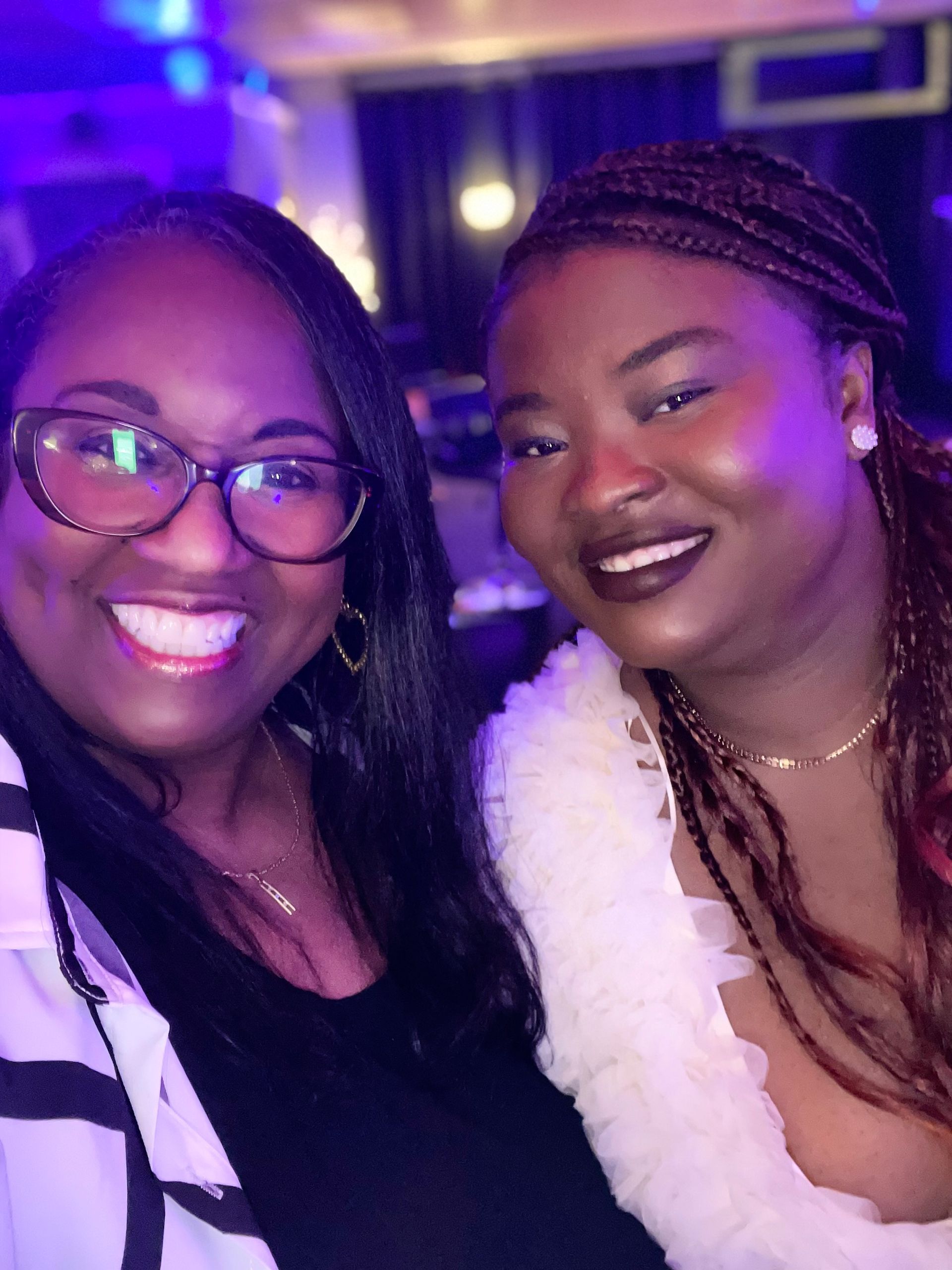 Two women are posing for a picture together and smiling for the camera.