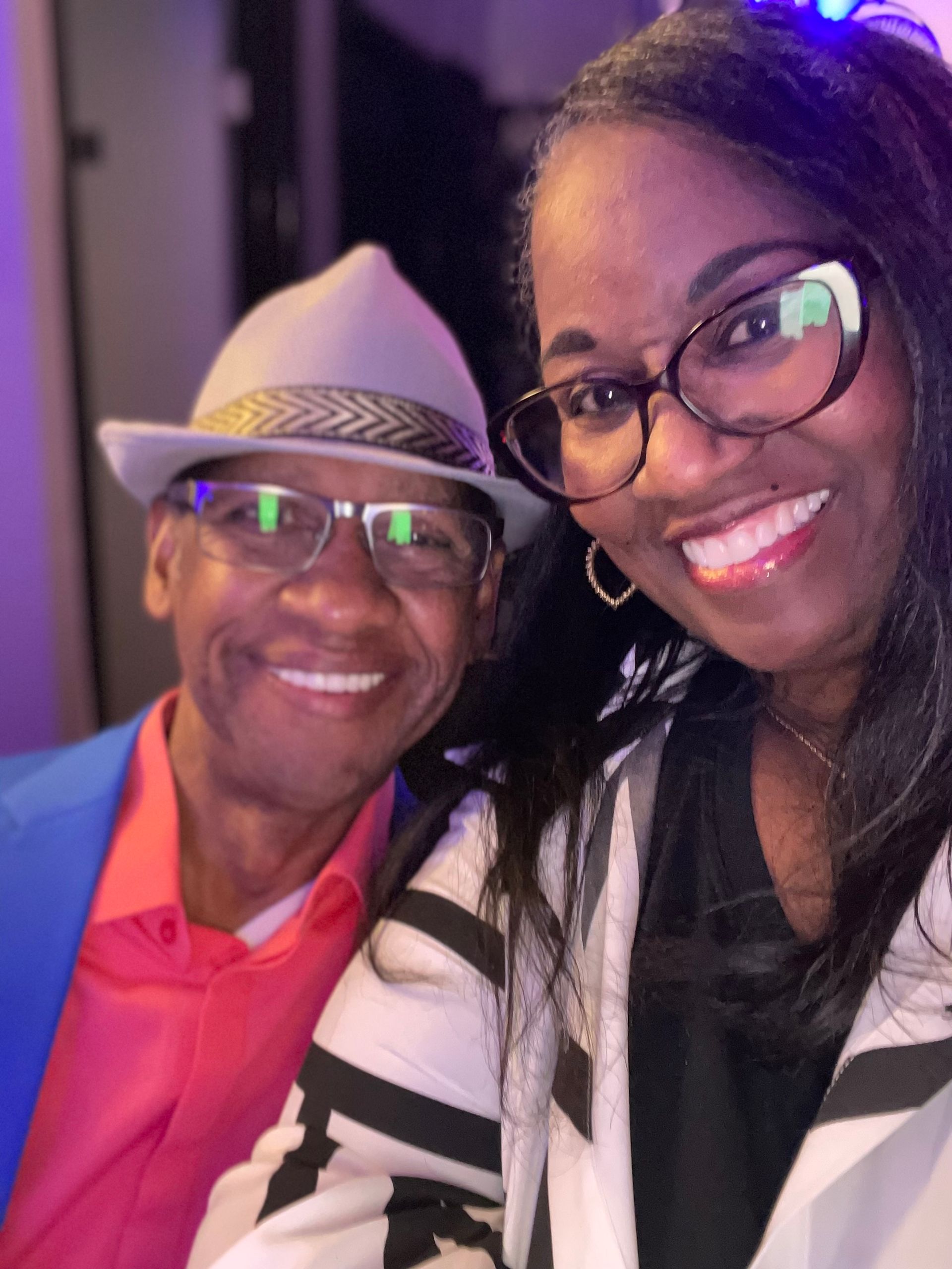 A man and a woman are posing for a picture and the woman is wearing glasses