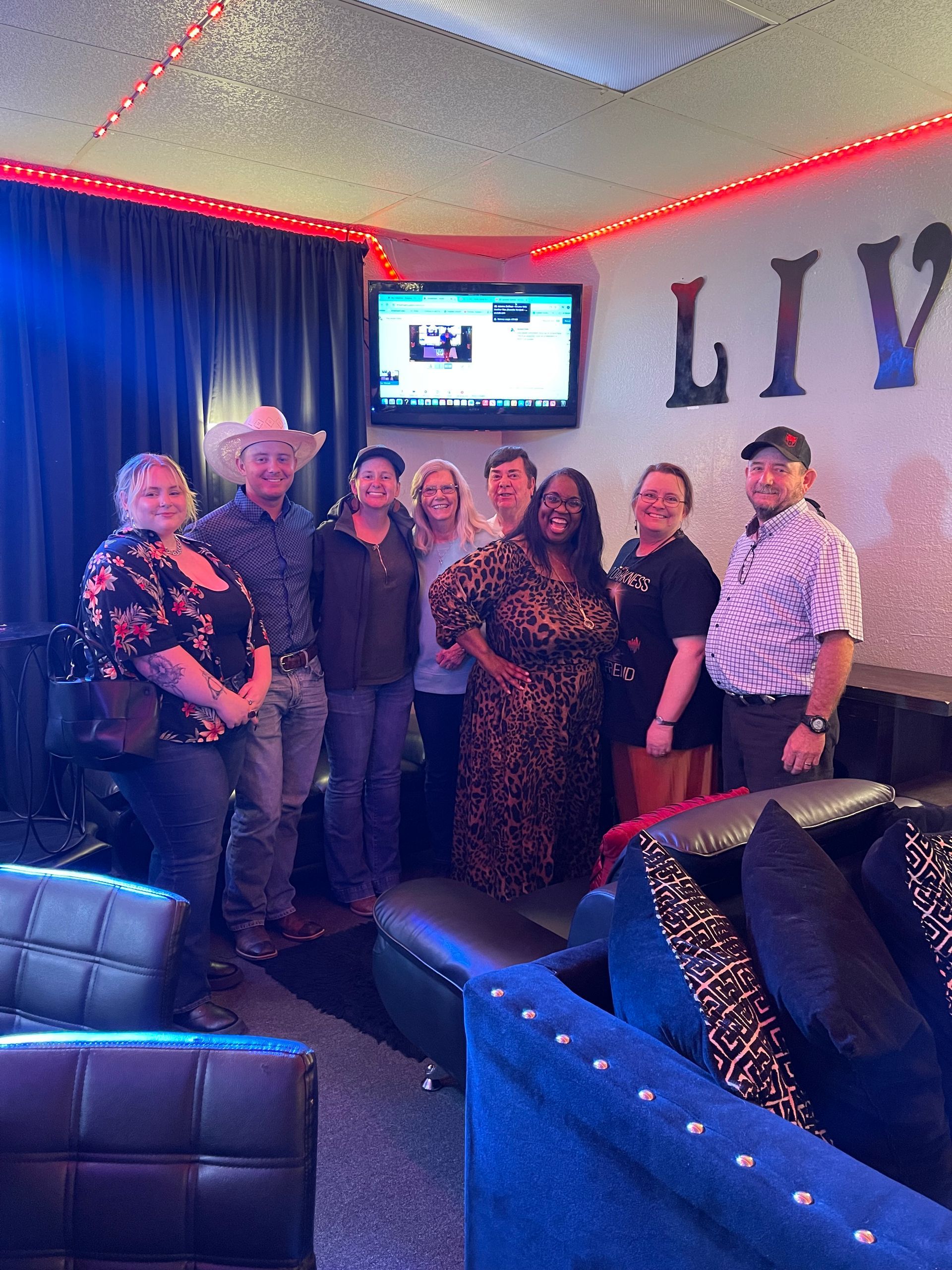 A group of people are posing for a picture in a living room.