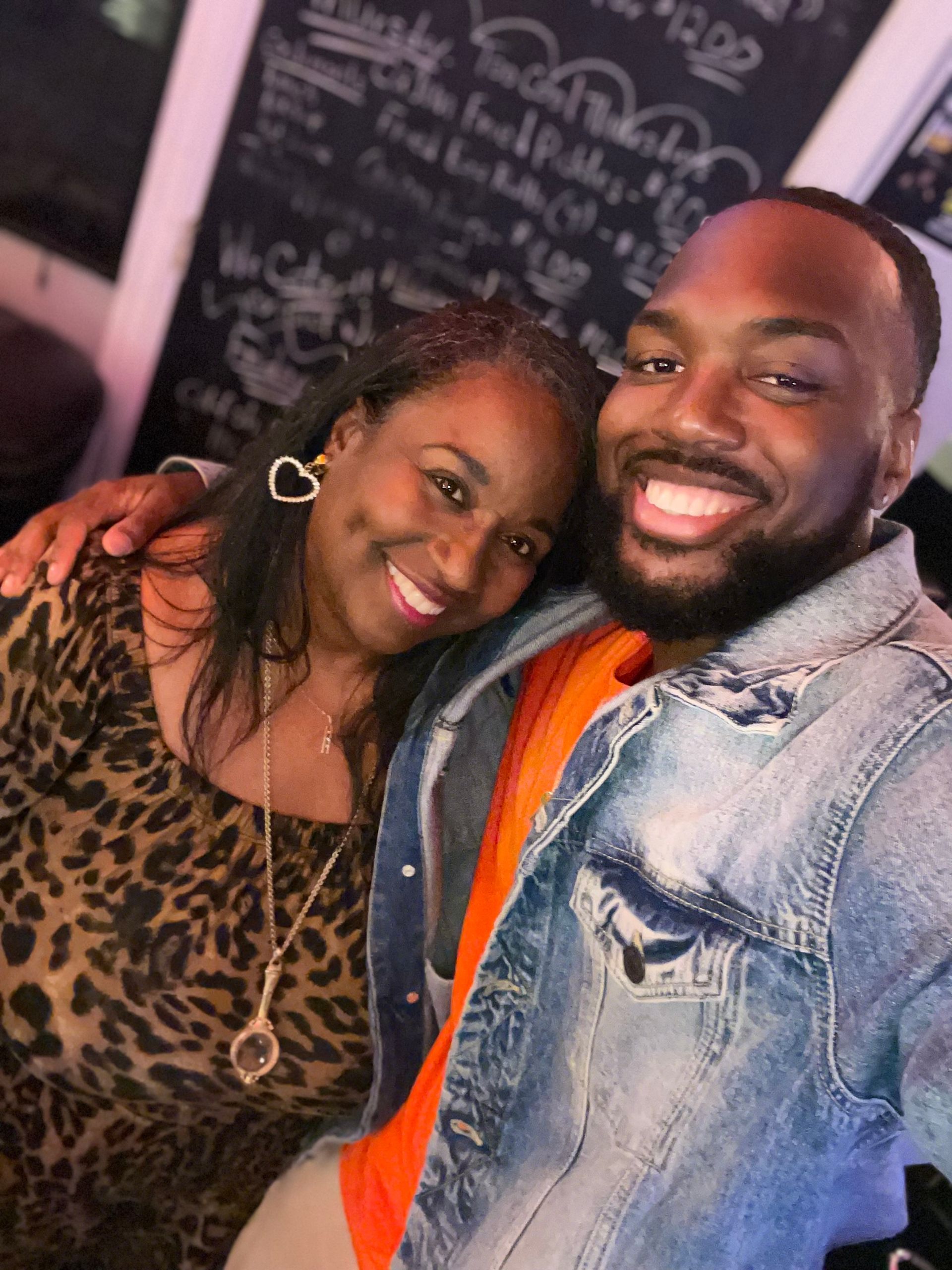 A man and a woman are posing for a picture and smiling.