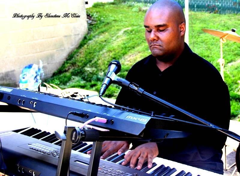 A man is playing a keyboard and singing into a microphone