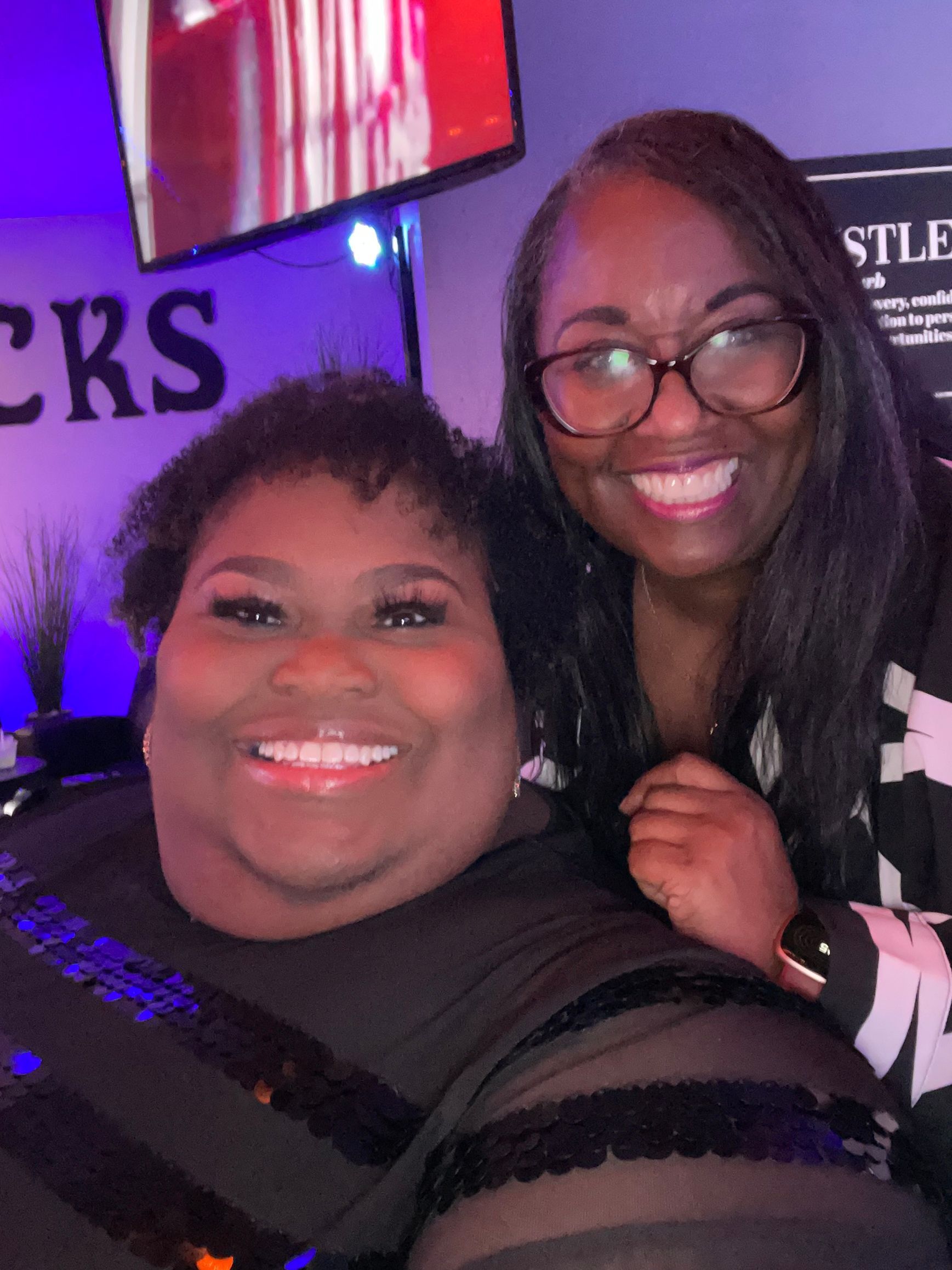 Two women are posing for a picture and smiling for the camera.