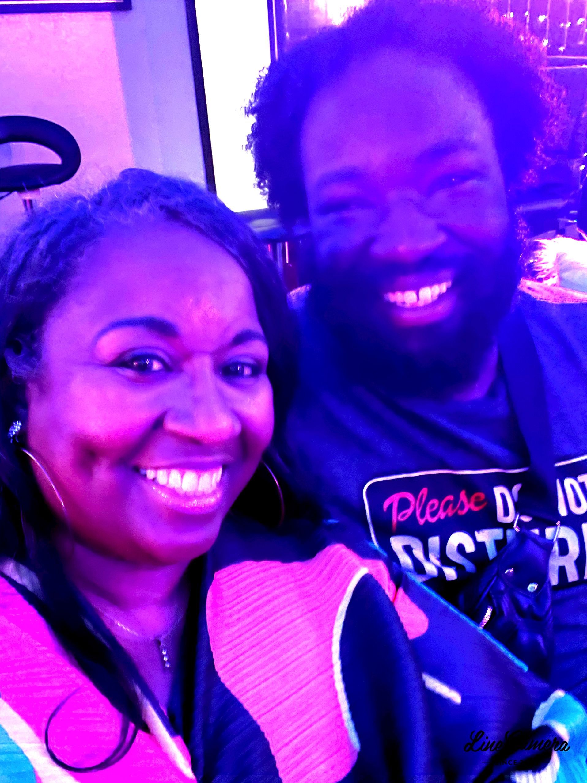 A man and a woman are posing for a picture and the man is wearing a shirt that says please do not disturb