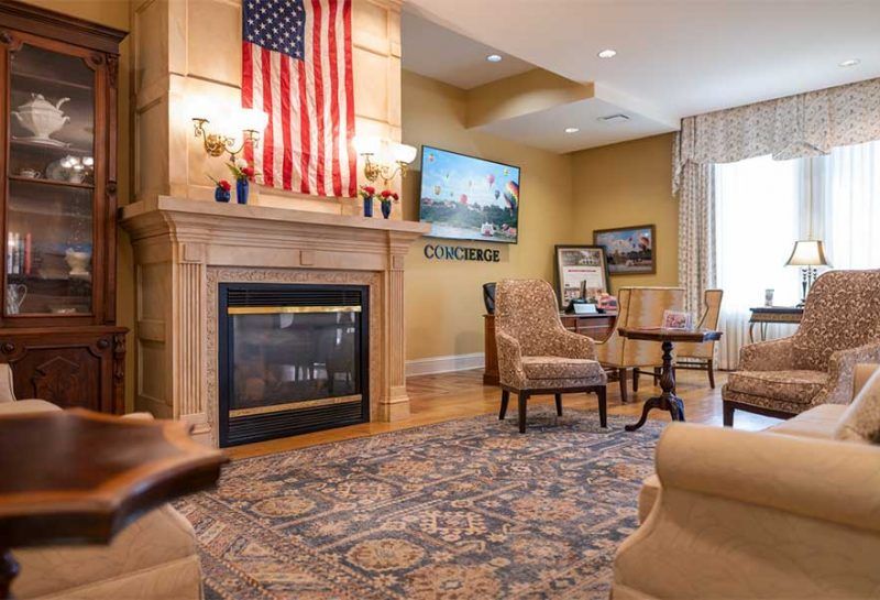 Living room with a fireplace, American flag, and antique furnishings.