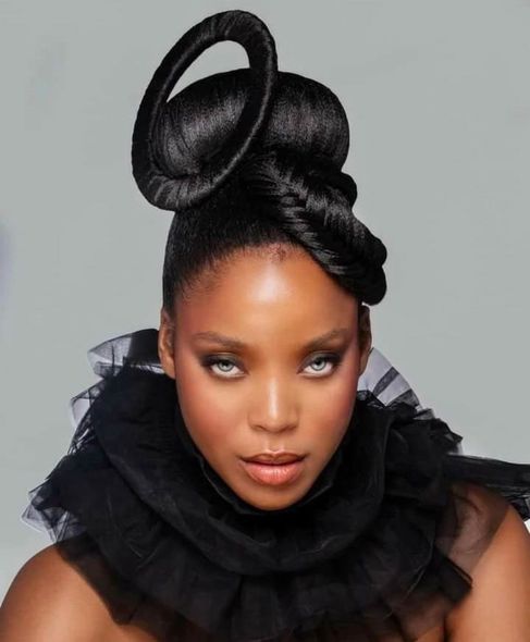 A woman with a bun on her head wearing a black ruffled collar