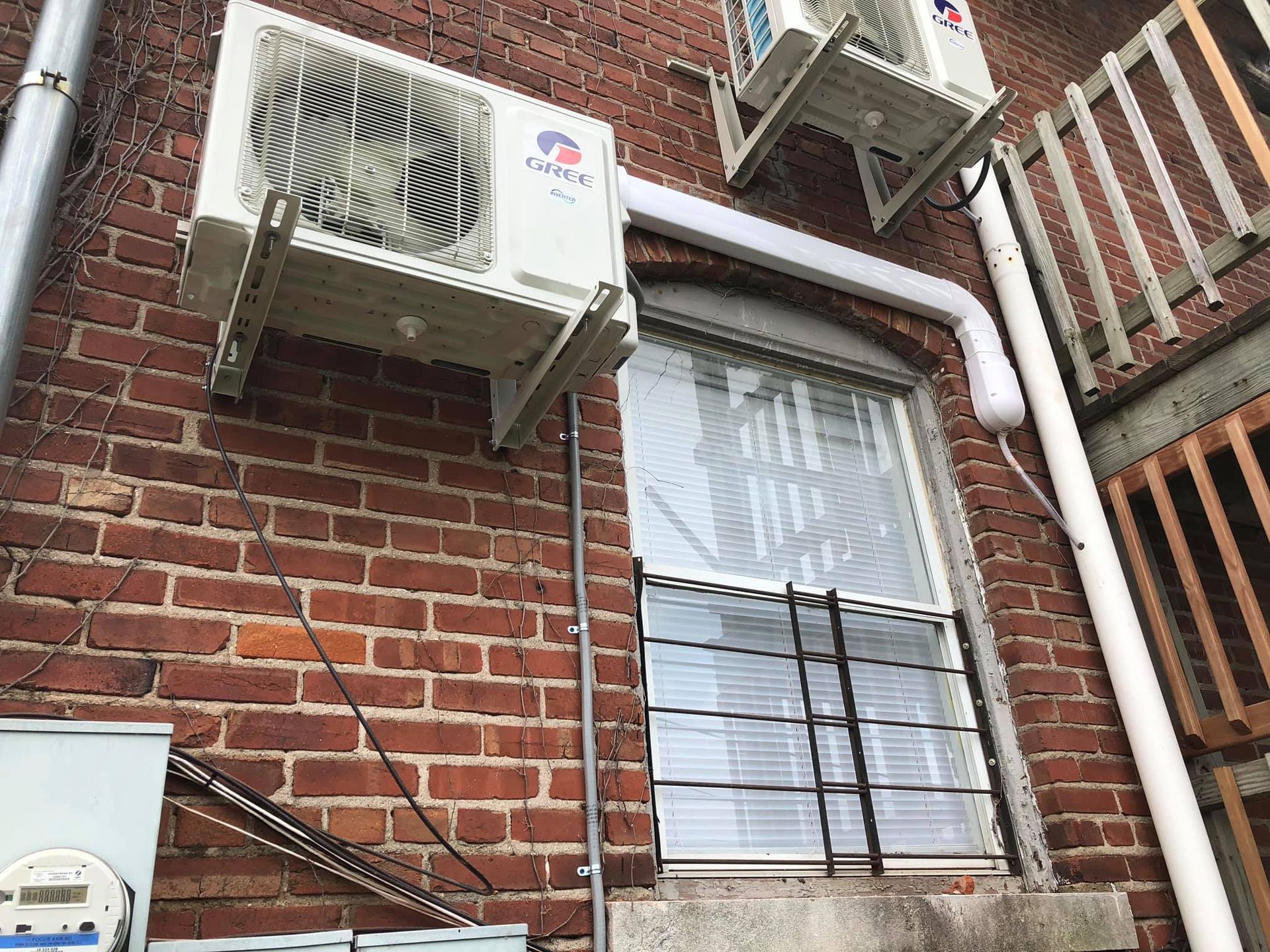 Gree ductless mini split AC units mounted on exterior brick wall