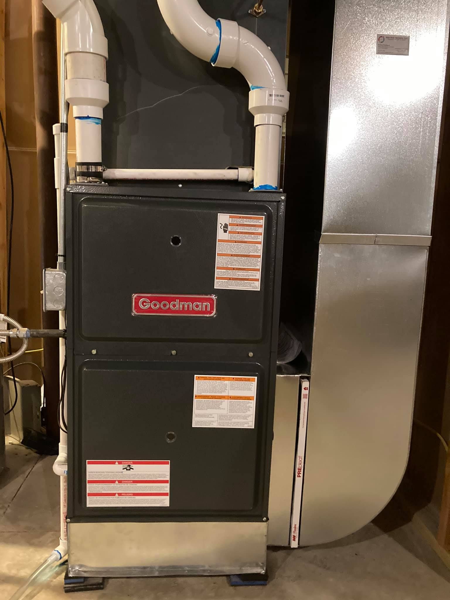 Goodman furnace installation with connected PVC vent pipes in residential basement