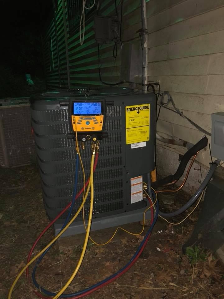 Outdoor AC unit under maintenance with digital gauge and refrigerant lines