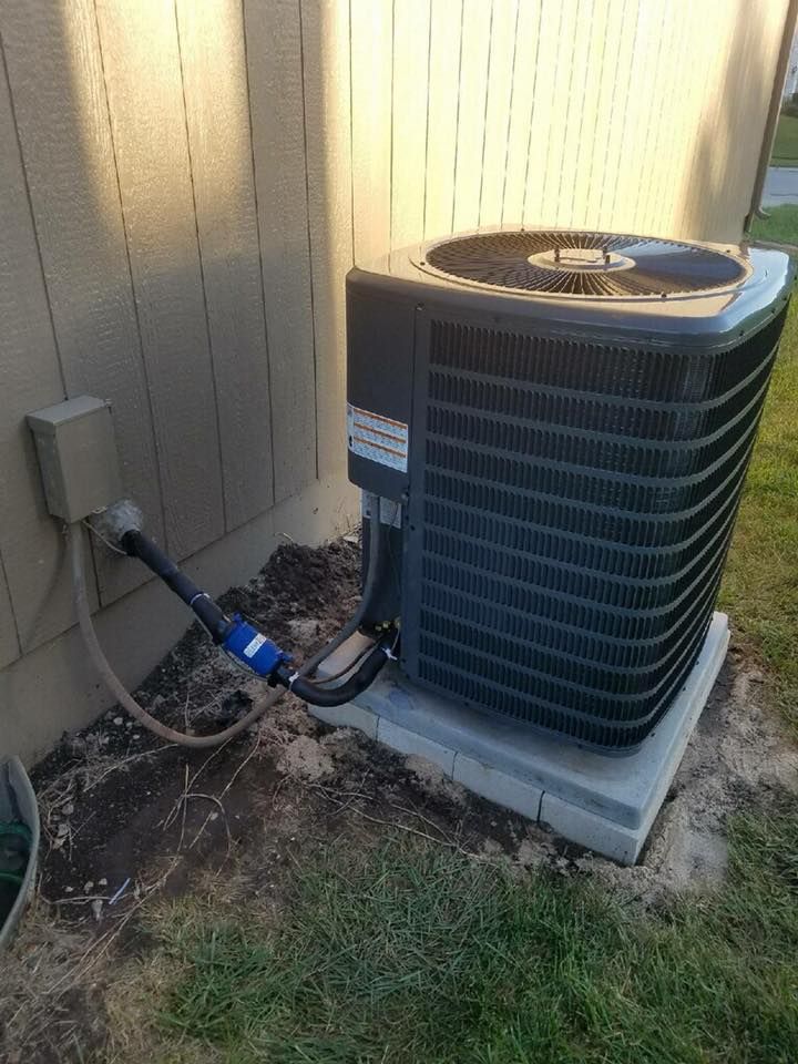 Outdoor HVAC condenser with copper piping connected to residential home