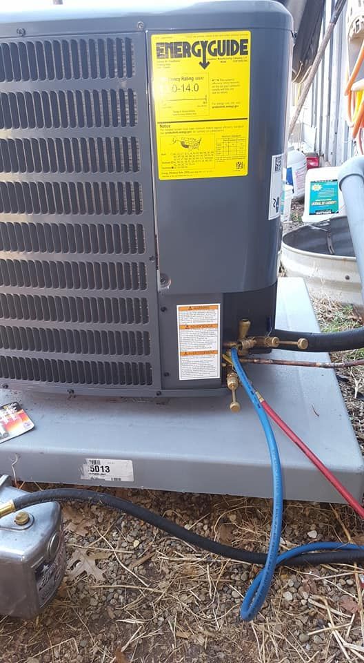 A black air conditioner is sitting on top of a metal platform.