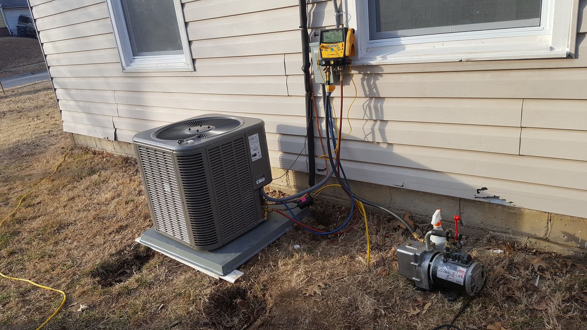 An air conditioner is sitting on the side of a house.
