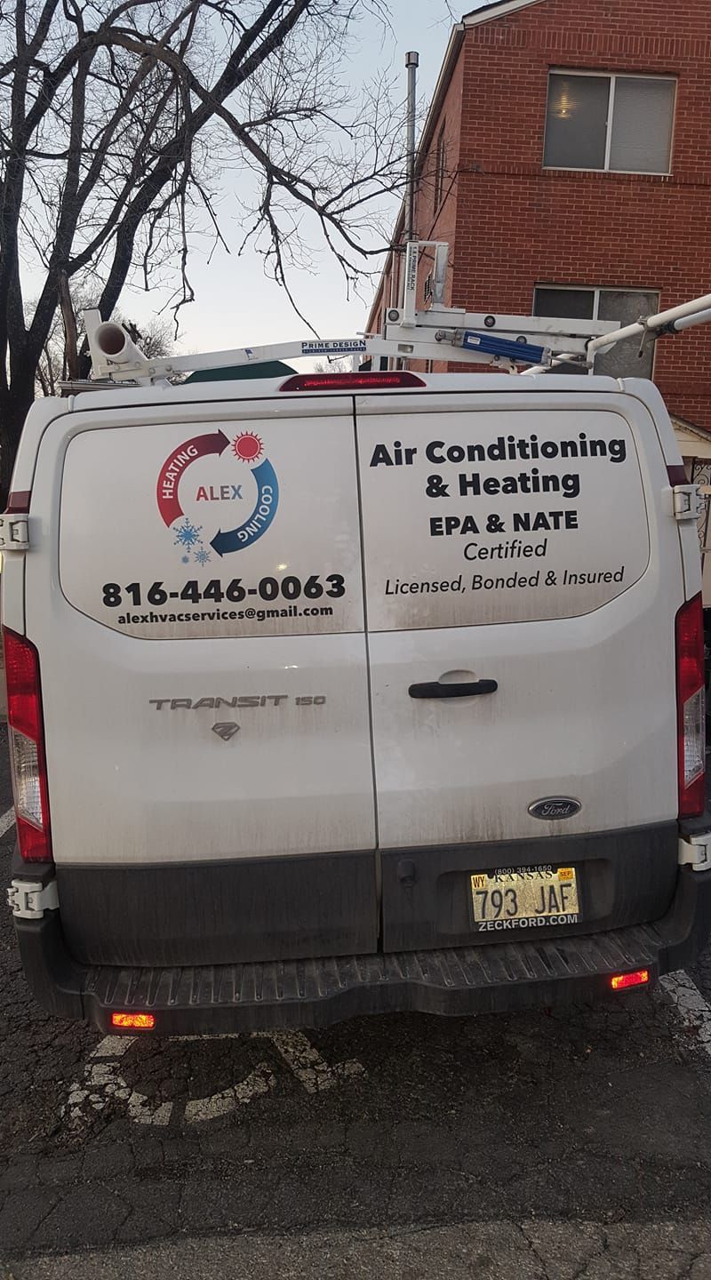 A white van is parked in front of a brick building.