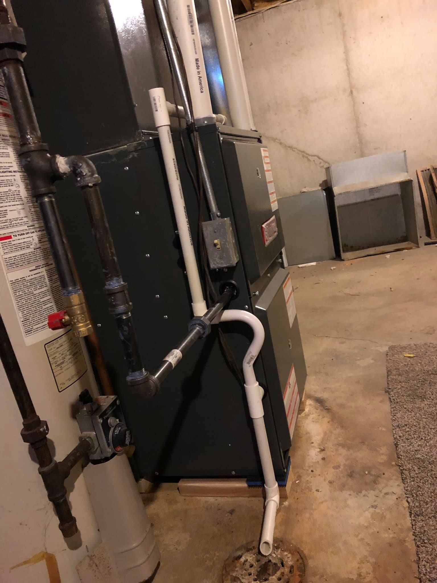 Residential HVAC furnace installation with connected PVC drainage and gas piping