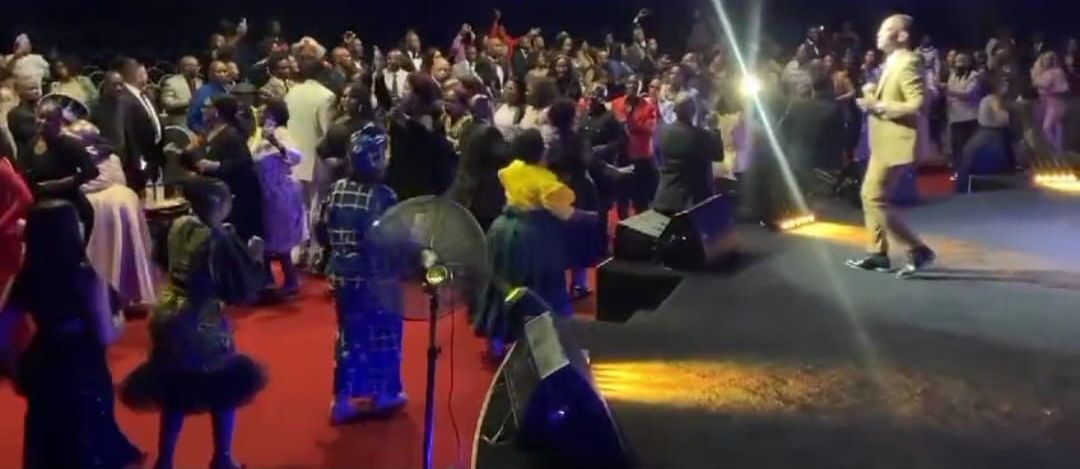 A crowd of people in formal attire at the 2023 Legends awards , with William Sejake singing on stage.