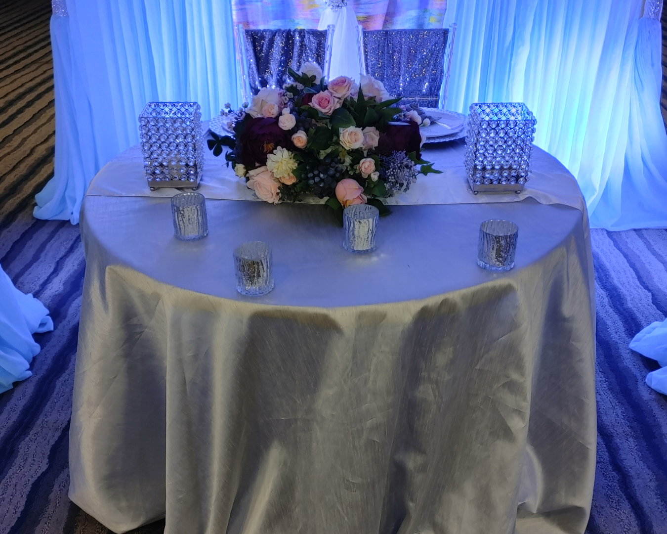 A table with a white tablecloth and a vase of flowers on it.