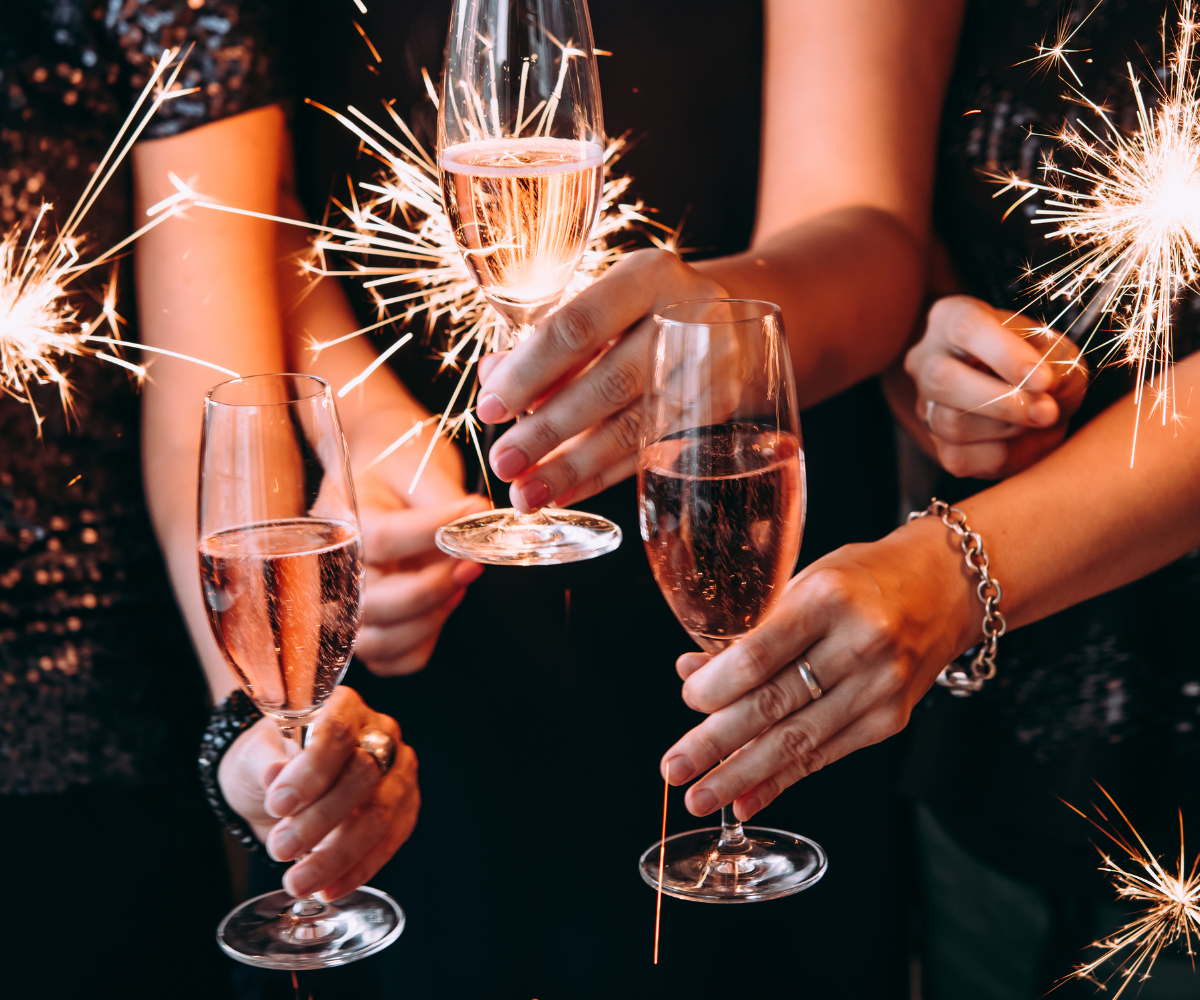 A group of people are holding sparklers and champagne glasses.