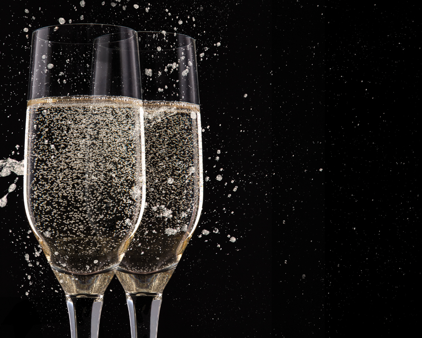 Two glasses of champagne are splashing on a black background.