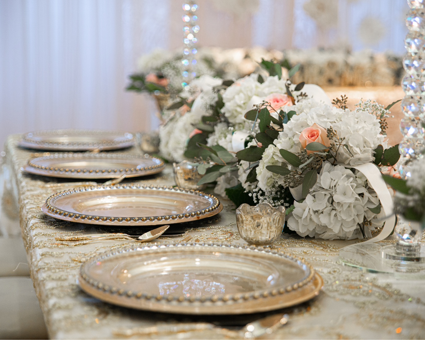 A table with plates , silverware , and flowers on it.
