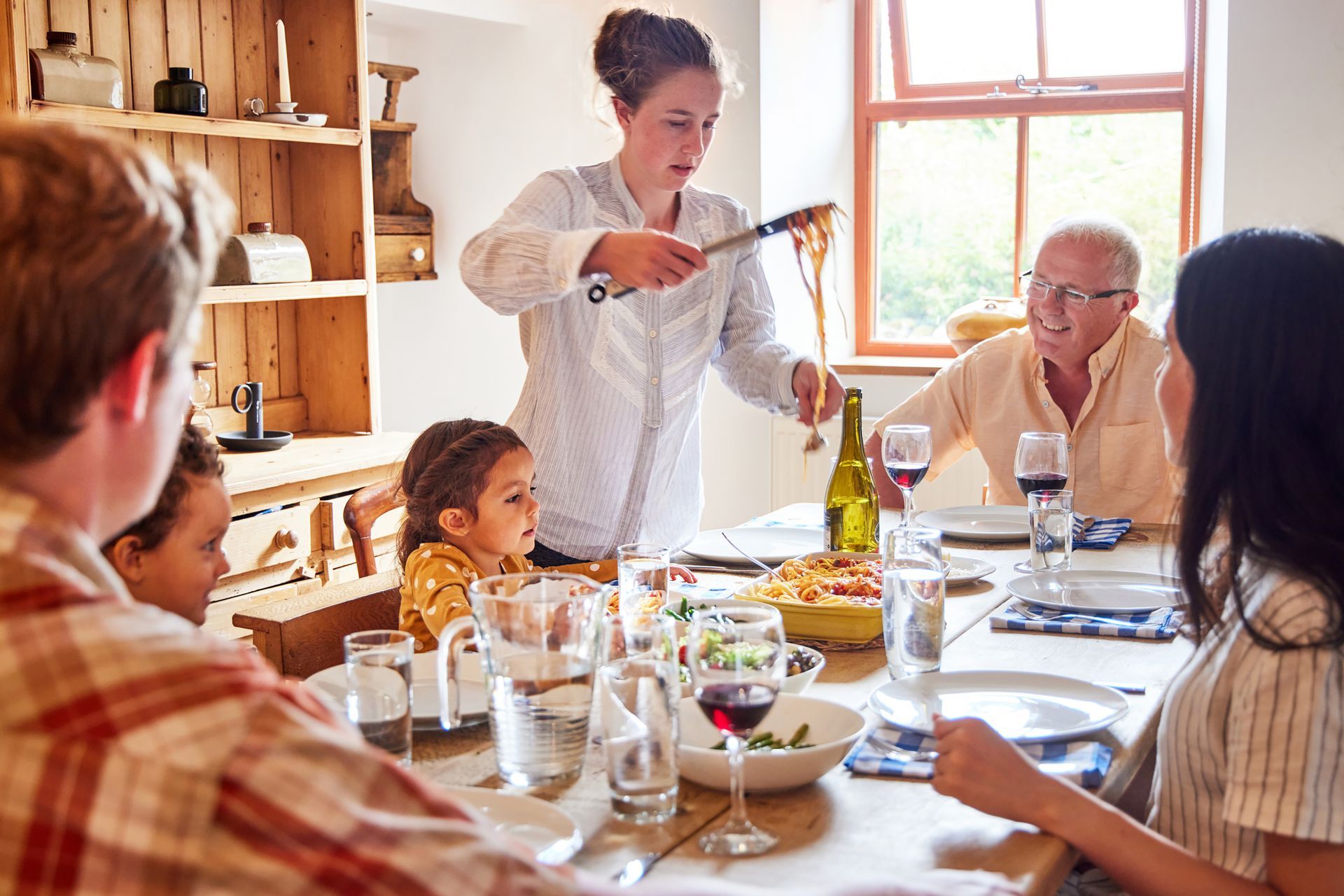 photograph of mom serving pasta for family