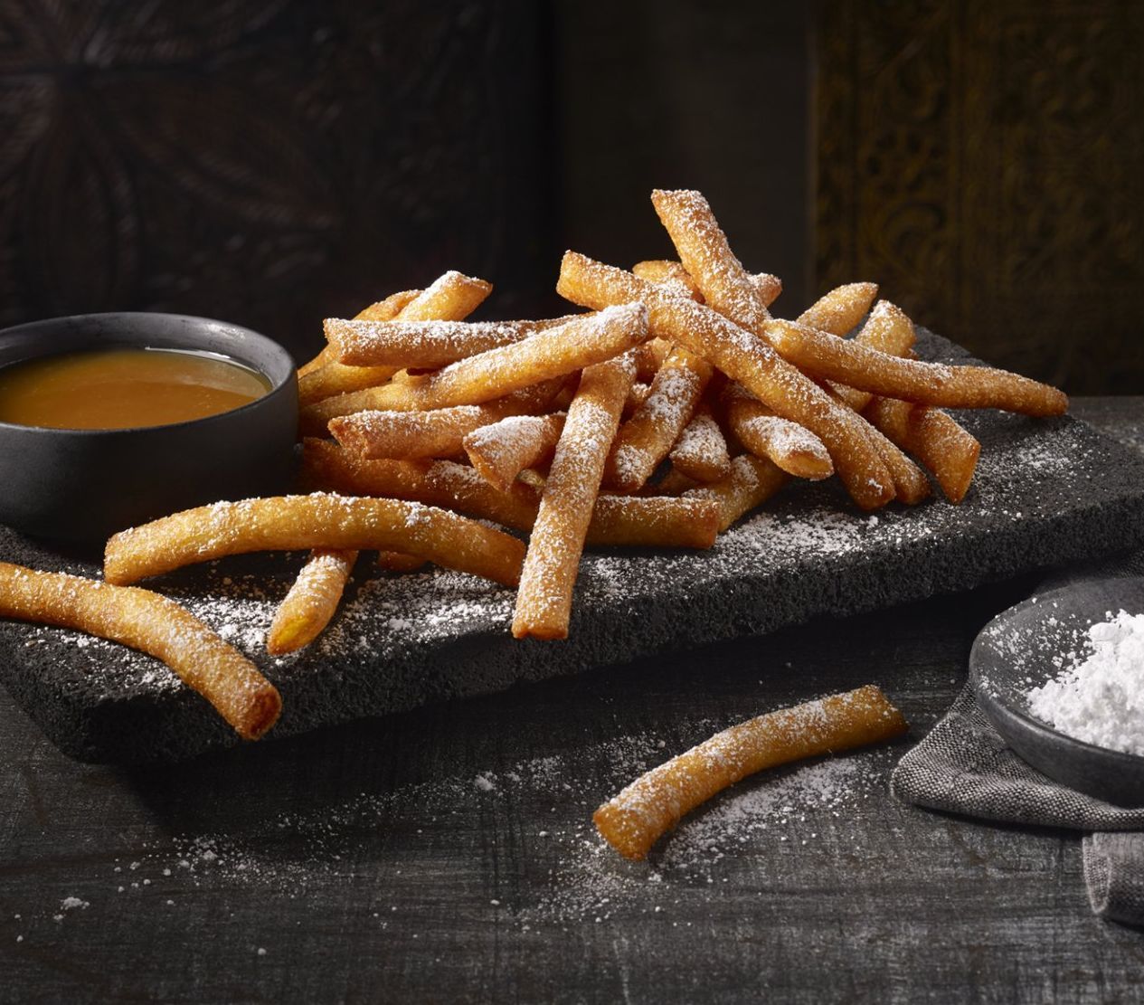 beautiful shot of ribs stacked with bbq sauce being put on top, shot by food photographer rusty hill
