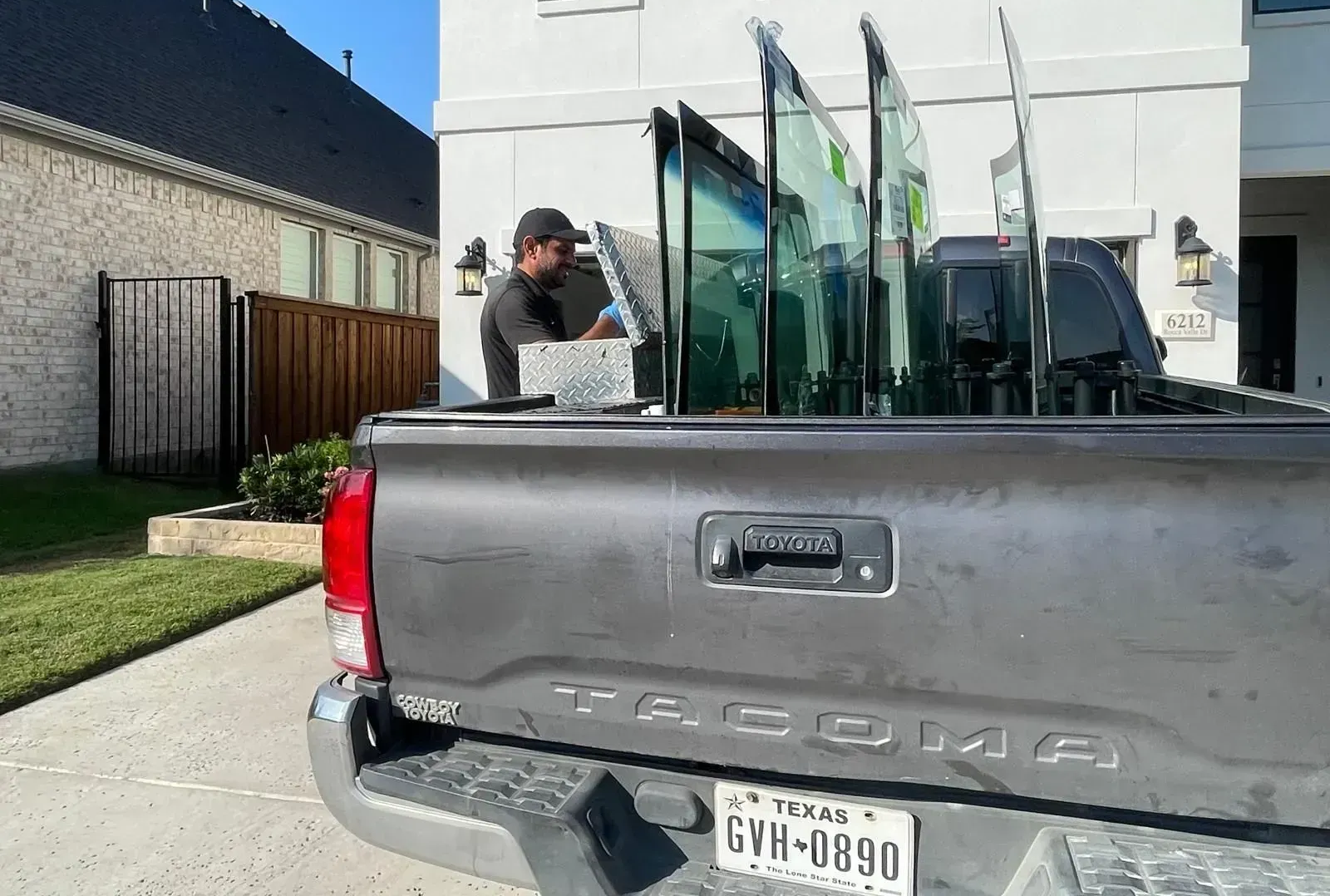 Car windshield replacement with suction cups, shop interior.