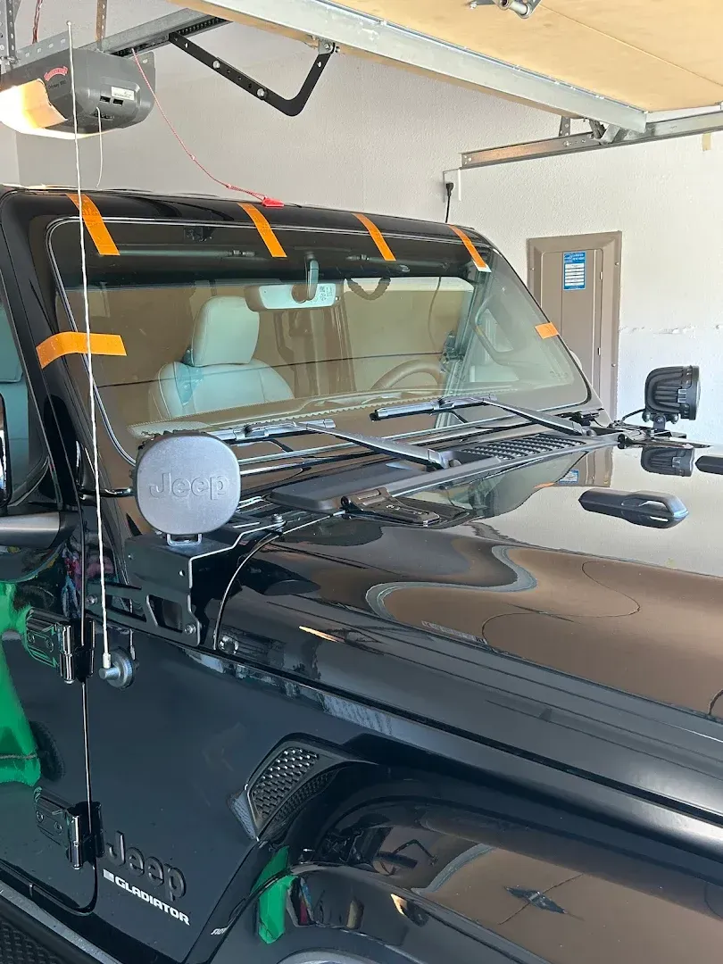 Black Jeep inside a garage. Orange tape marks the windshield's edges.