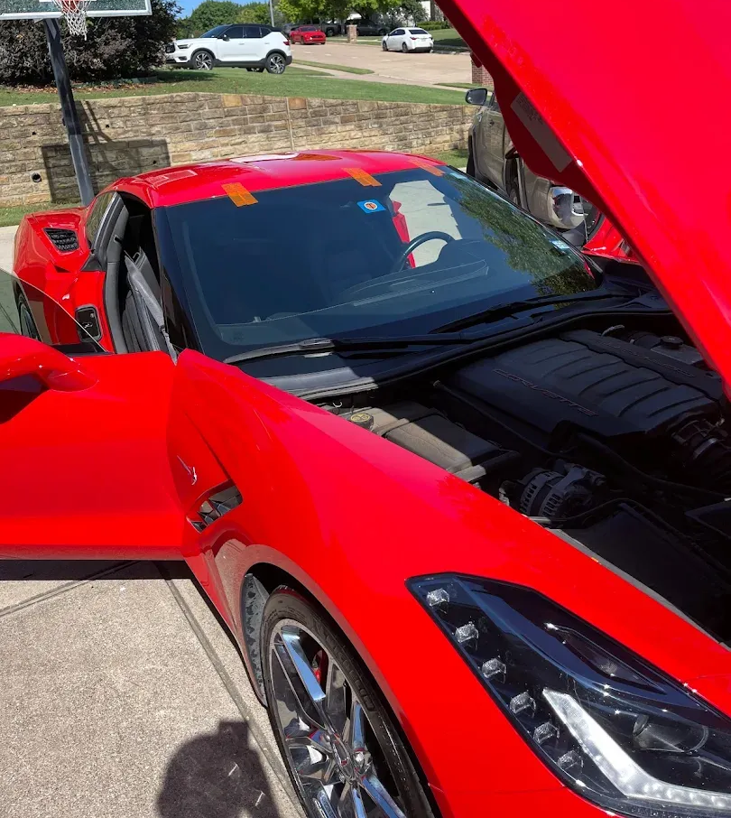 Car windshield replacement with suction cups, shop interior.