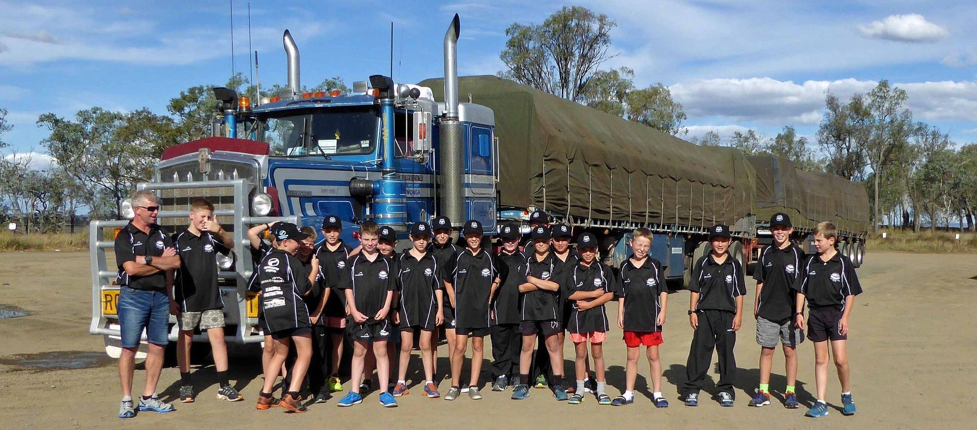 A group of people standing in front of a large truck