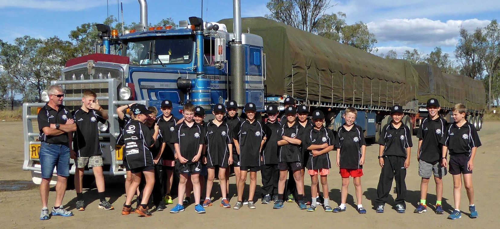 A group of people standing in front of a large truck