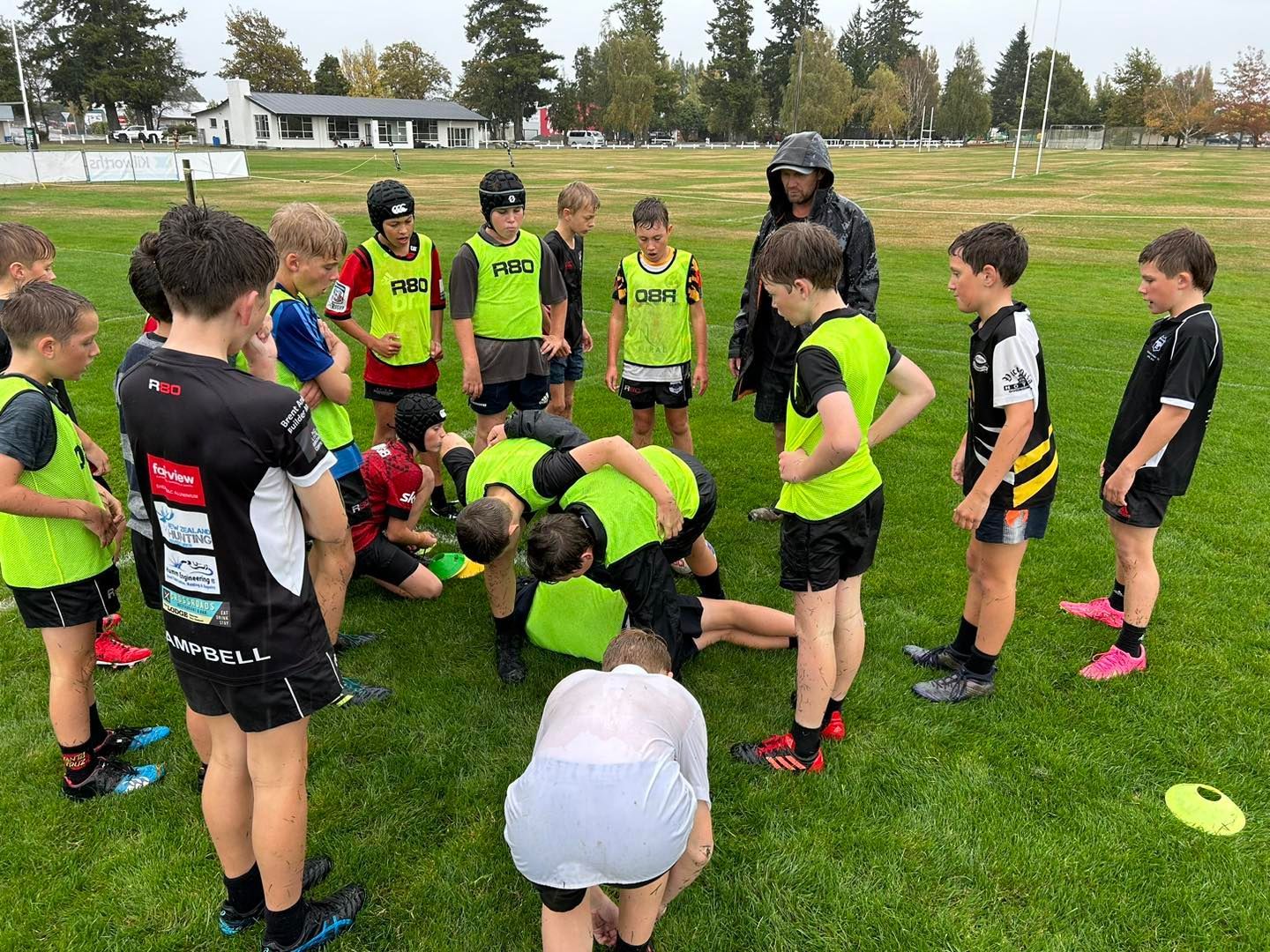 A group of young boys are standing in a circle on a field.
