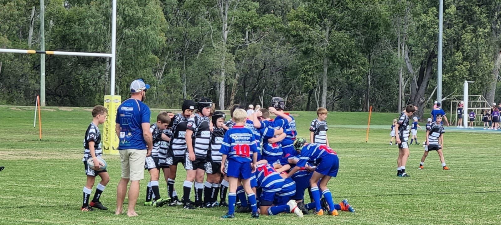 A group of young boys are huddled together on a soccer field.