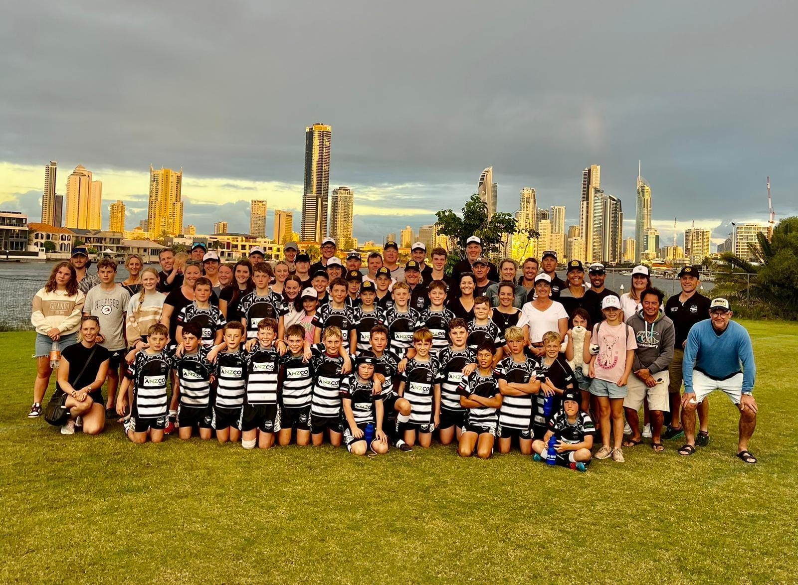A group of people posing for a picture with a city skyline in the background