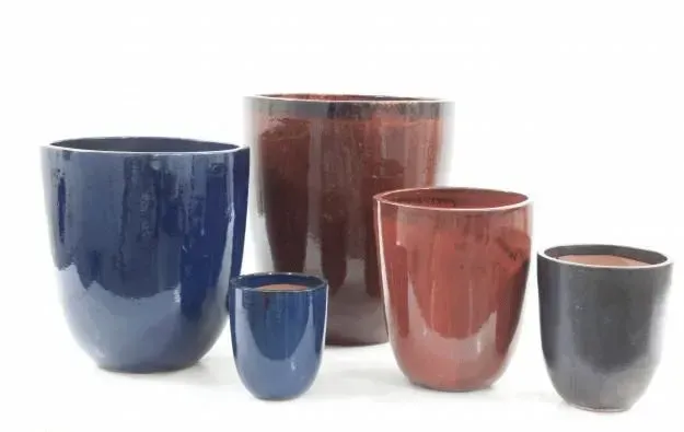 Five glazed ceramic planters in blue, red, and black on a white background.
