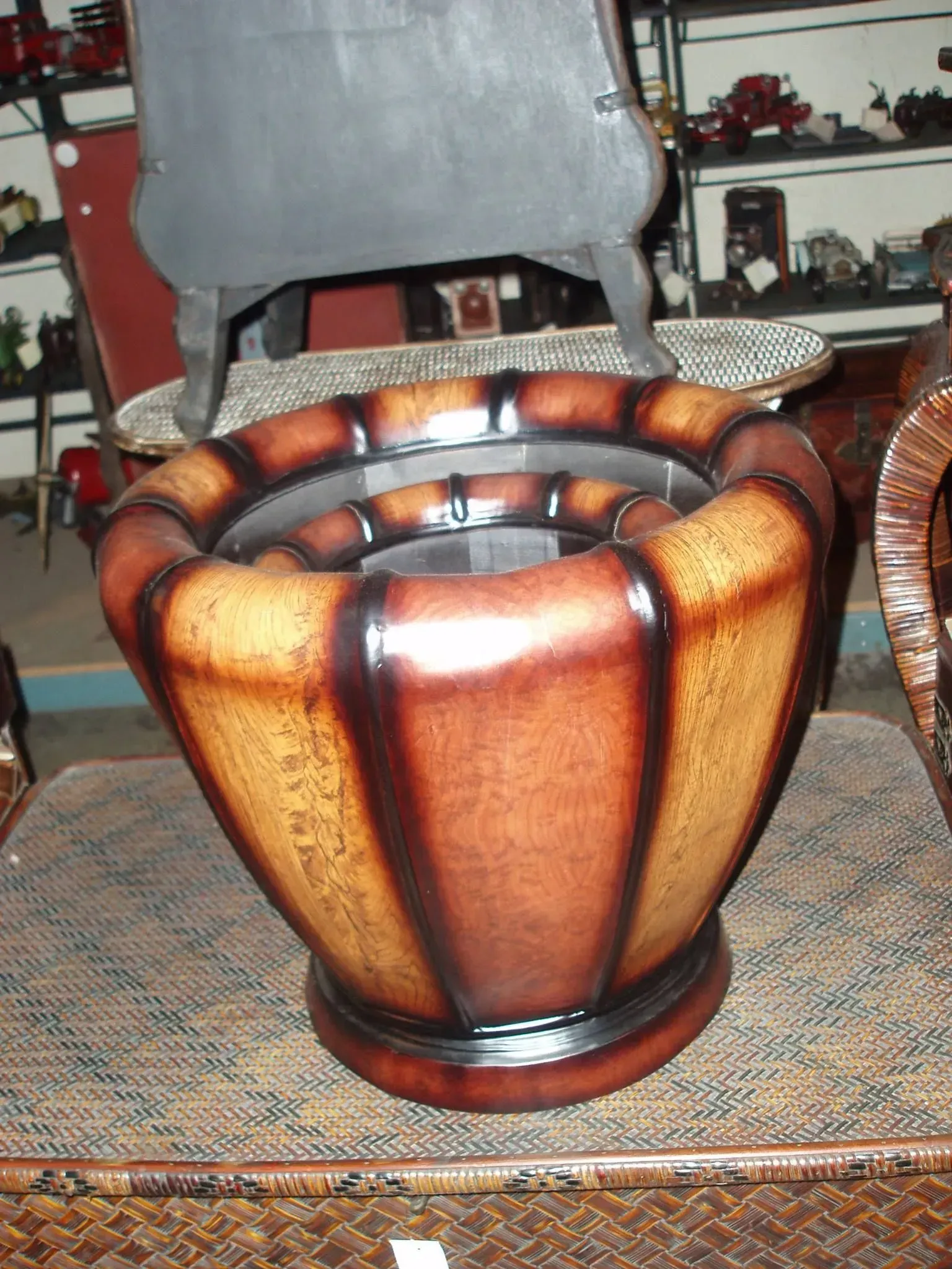 Brown and tan fluted planter on woven mat, dark trim.