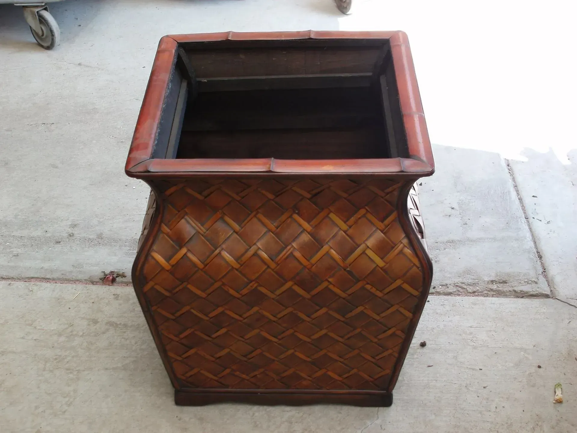 Brown woven bamboo planter, square shape, outdoors.