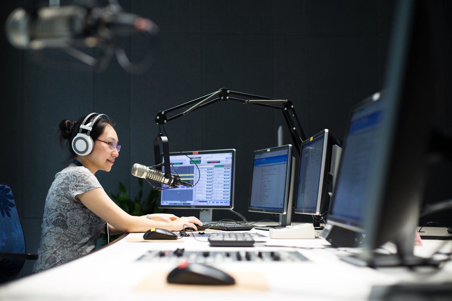 young woman dj works in modern broadcast studio