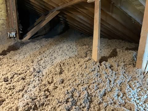 There is a lot of insulation in the attic of a house.