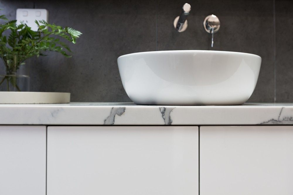 A White Sink is Sitting on Top of a White Counter in a Bathroom — Elite Stone in Tweed Heads South, NSW