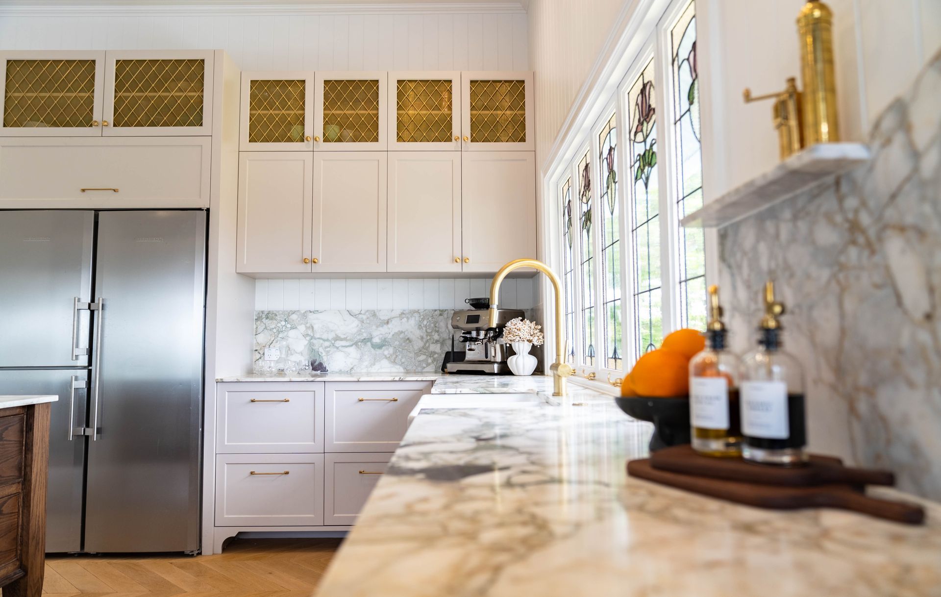 A Kitchen With White Cabinets, Gold-patterned Cupboards, and Marble Countertops — Elite Stone in Tweed Heads South, NSW