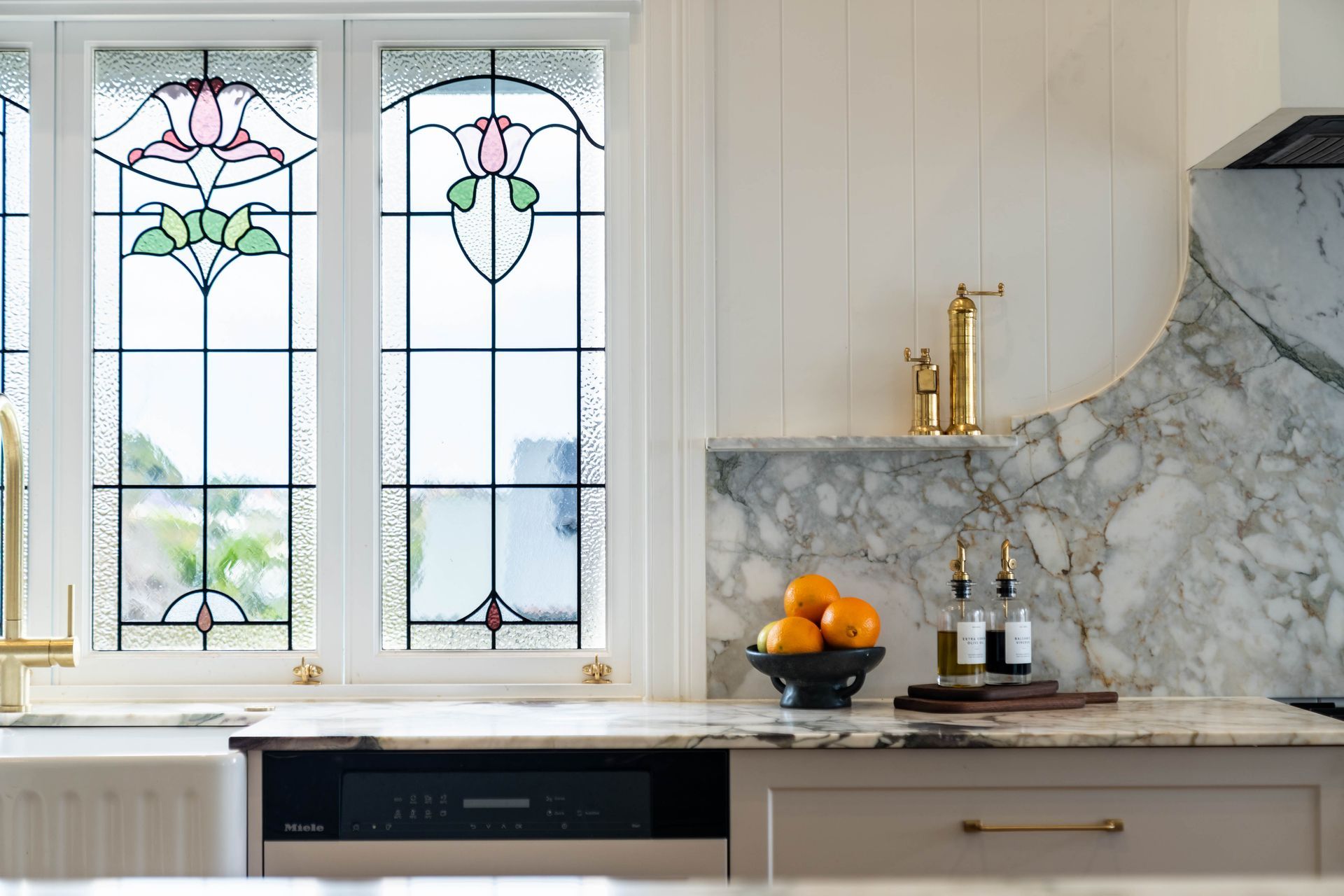 A Stained Glass Window Above a Kitchen Counter With Marble Backsplash — Elite Stone in Tweed Heads South, NSW