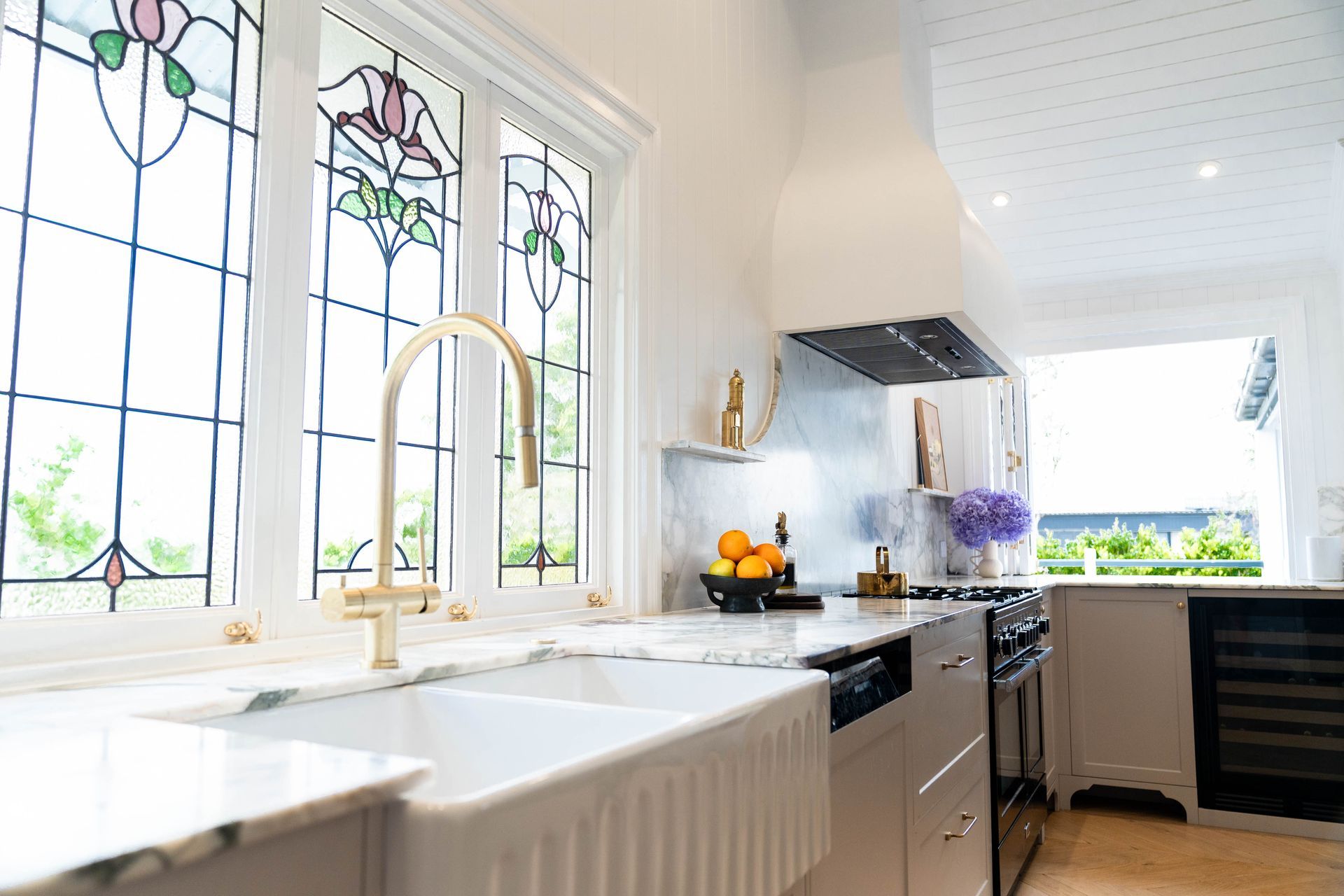 A Bright, Modern Kitchen Featuring a White Farmhouse Sink and Stained-glass Windows — Elite Stone in Tweed Heads South, NSW