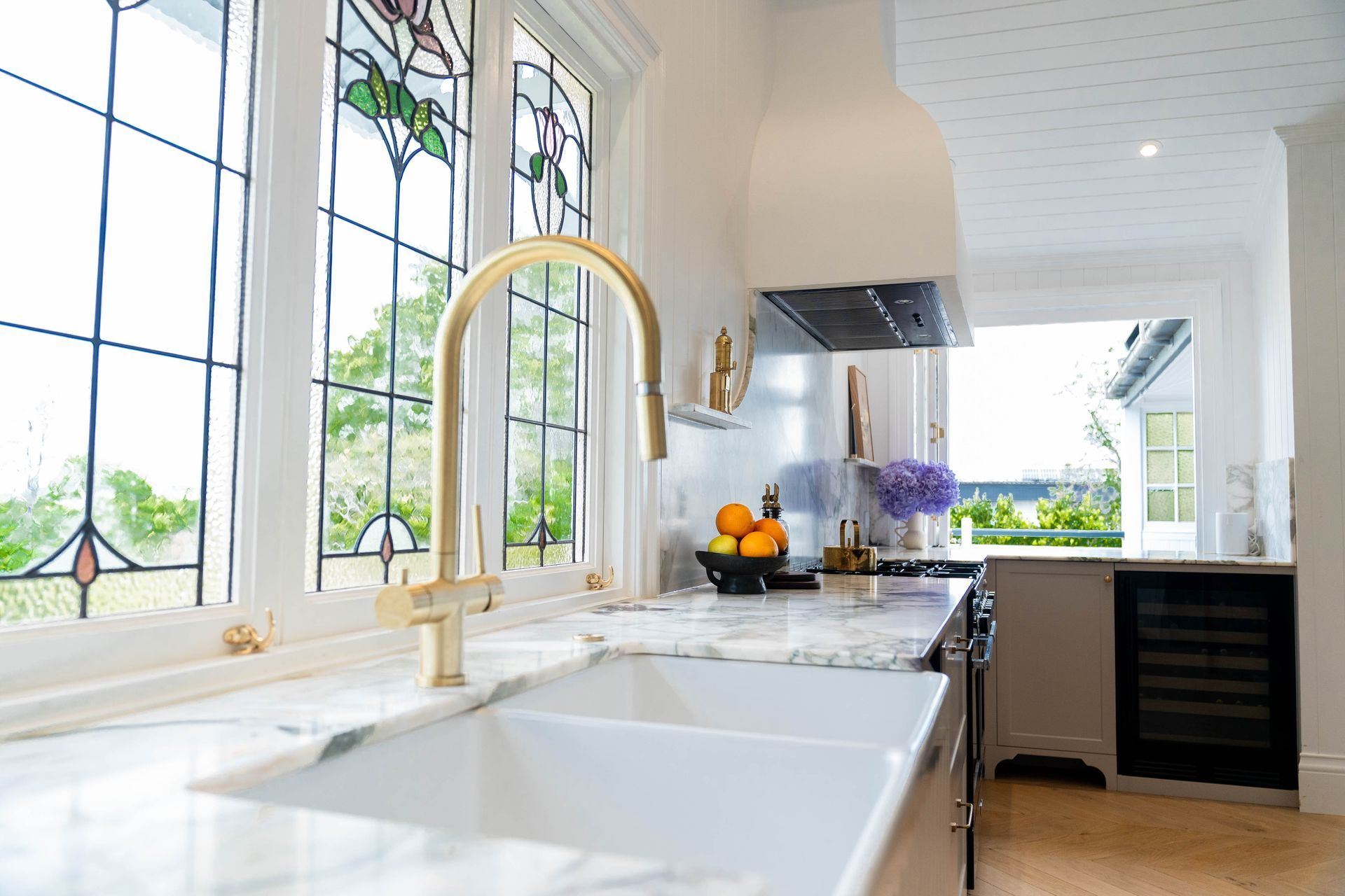 A Bright Kitchen Featuring a White Farmhouse Sink, Faucet, and Stained-glass Windows — Elite Stone in Tweed Heads South, NSW