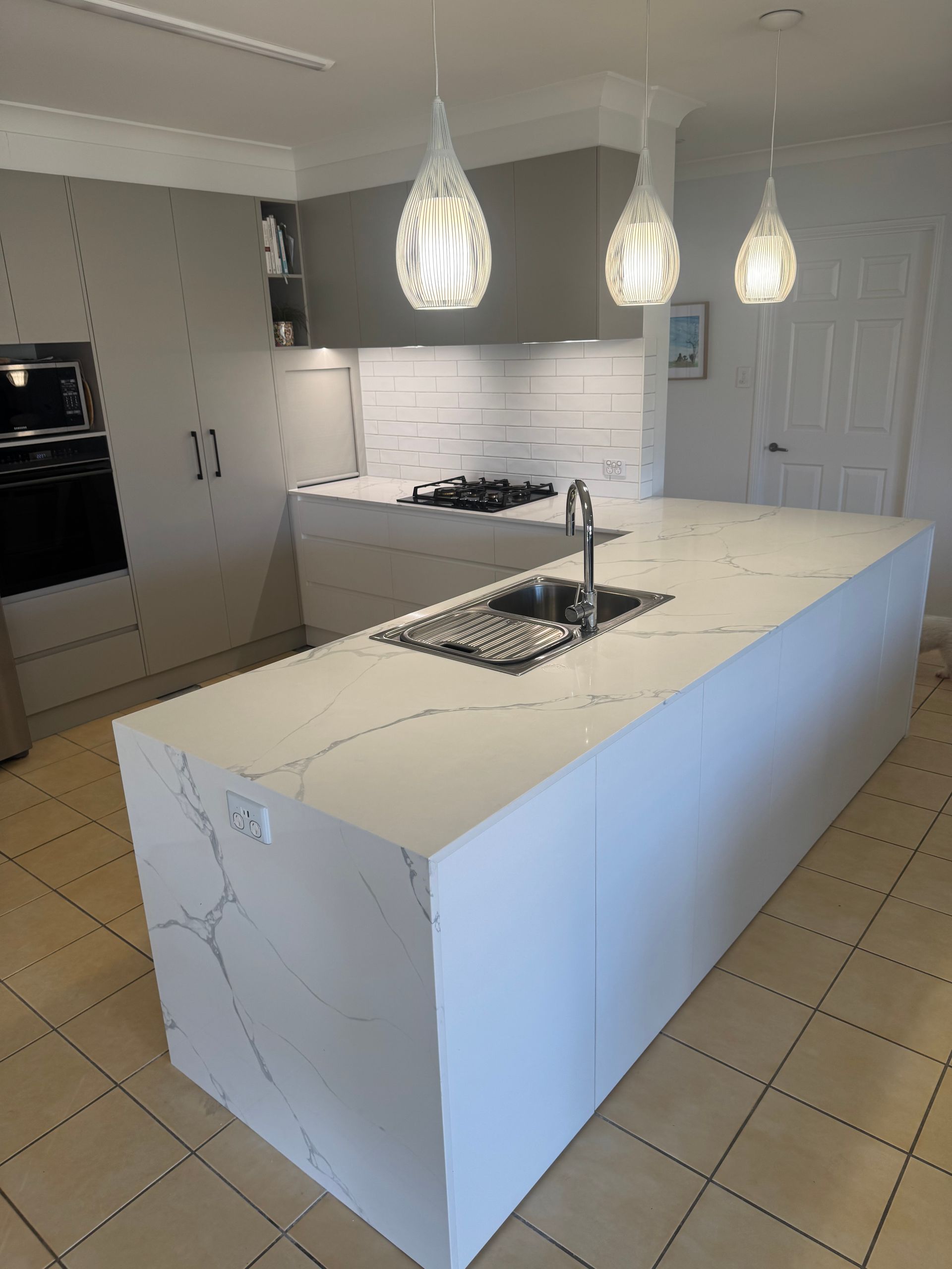 A Kitchen With White Cabinets and a Stove Top Oven — Elite Stone in Tweed Heads South, NSW