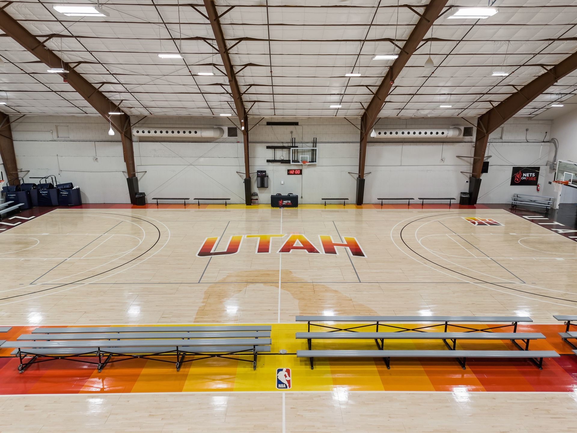 A large indoor basketball court with the word utah painted on the floor.