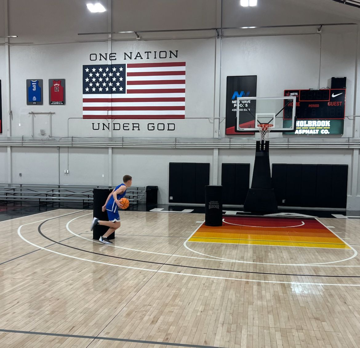 A basketball court with the words one nation under god on the wall