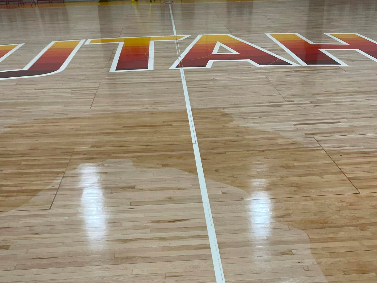 The word utah is painted on the floor of a basketball court
