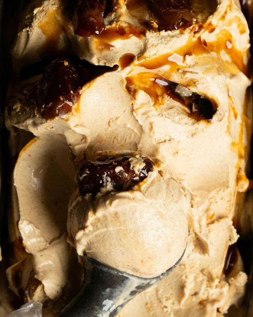 A close up of a spoon in a container of ice cream.