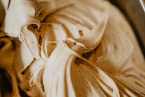 A close up of a bowl of ice cream with a spoon in it.