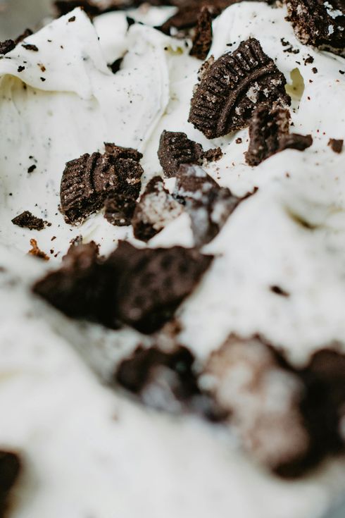 A close up of a bowl of ice cream with oreos on top.