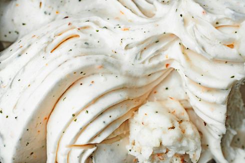 A close up of a white frosting with a bite taken out of it.